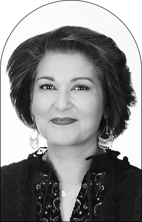 Black and white portrait of a woman with short, styled hair, wearing dangling earrings and a dark top with decorative details—a perfect muse for modern design concepts—posed with a slight smile before a plain background.